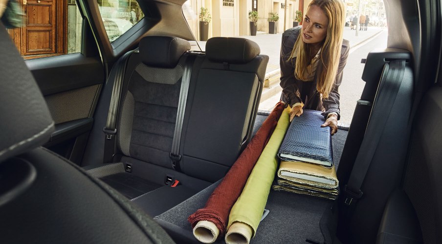 Servizi e manutenzione per vetture nuove SEAT – Una donna sistema alcuni oggetti nello spazio posteriore di una vettura con i sedili ripiegati per creare più spazio