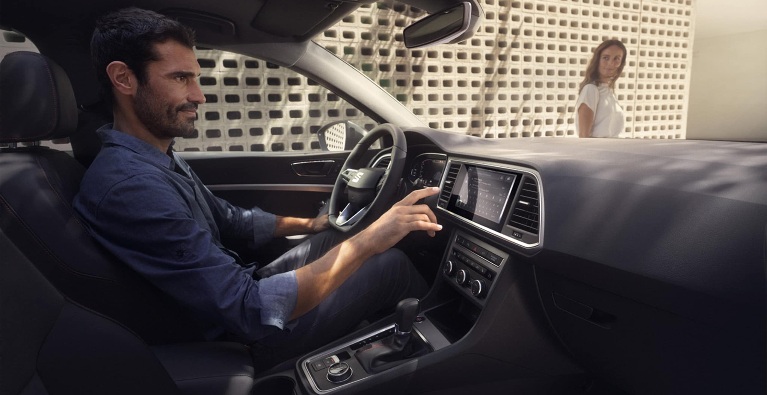 Servizi e manutenzione per vetture nuove SEAT – un guidatore preme un tasto sul sistema di navigazione satellitare 
