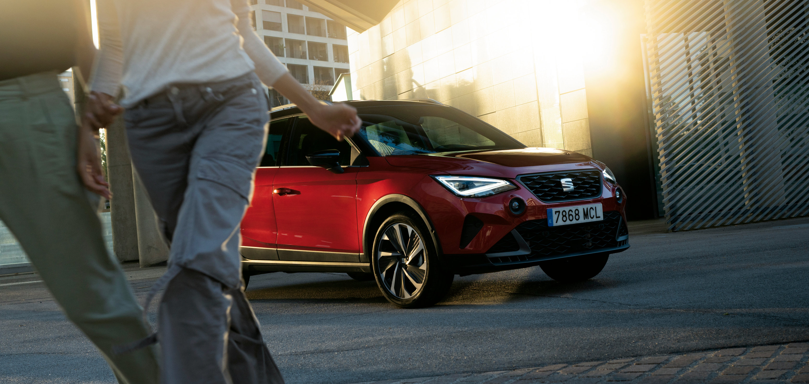Servizi e manutenzione per vetture nuove SEAT – vista anteriore, immagine tagliata di una donna appoggiata sul cofano di una nuova SEAT