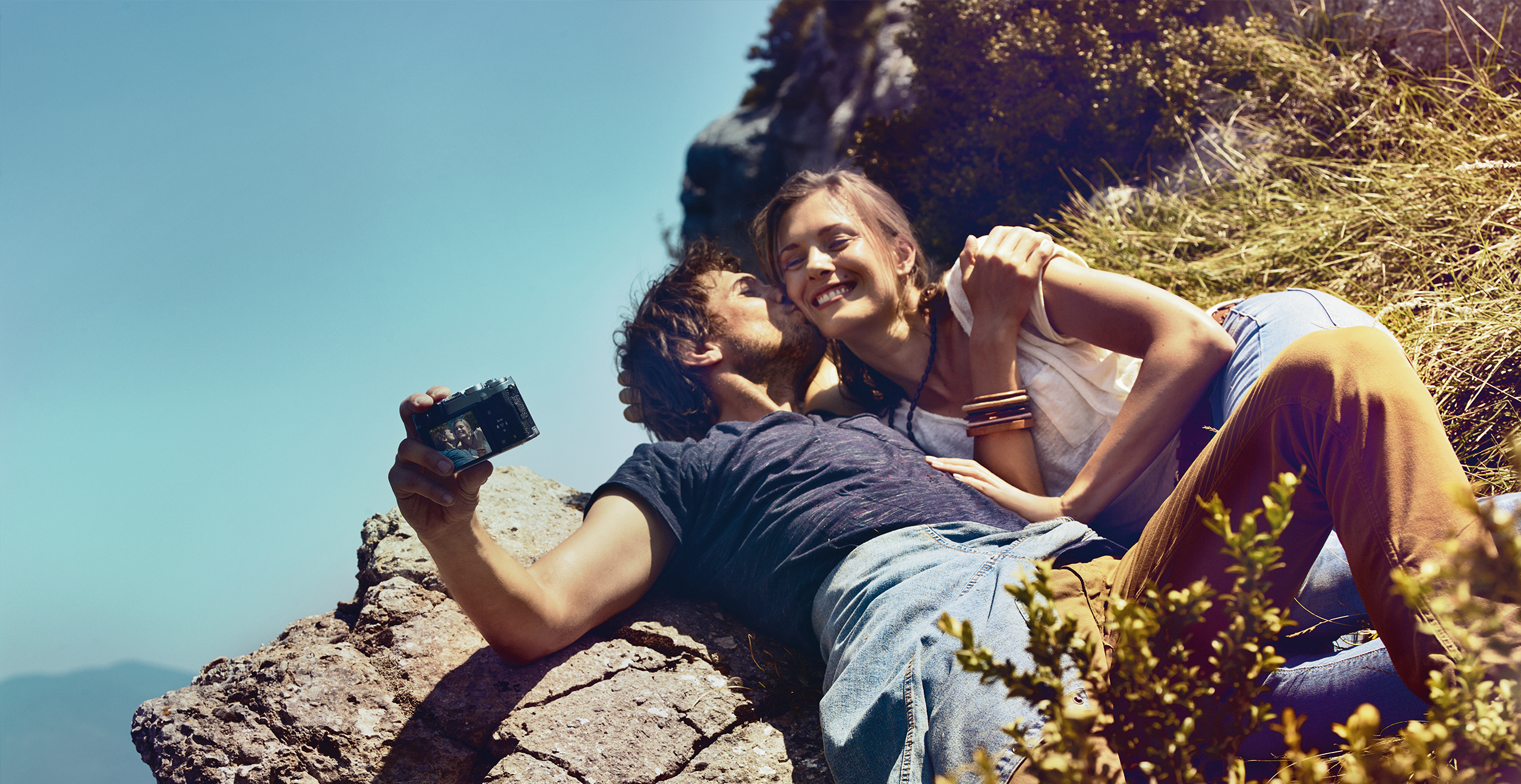 Giovane coppia stesa al sole che scatta un selfie – Offerte sull’usato coperto da garanzia SEAT