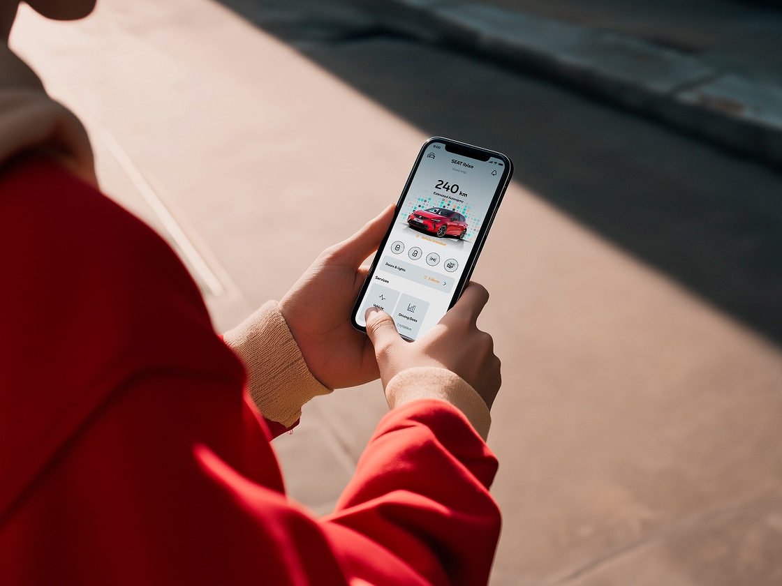 Persona che tiene il proprio smartphone utilizzando le funzioni remote del sedile