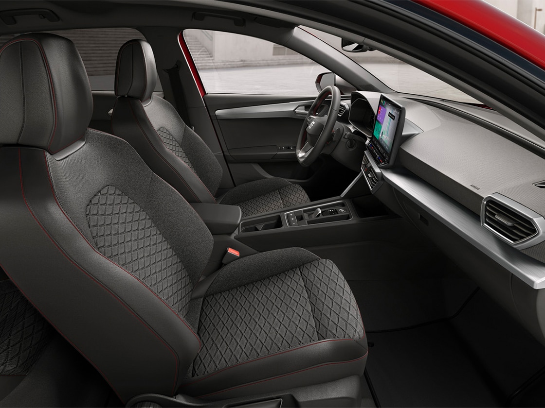 Vista degli interni della SEAT Leon che mostra i sedili Comfort con rivestimento di stoffa per FR, che uniscono un supporto ergonomico e un design elegante per un viaggio confortevole.