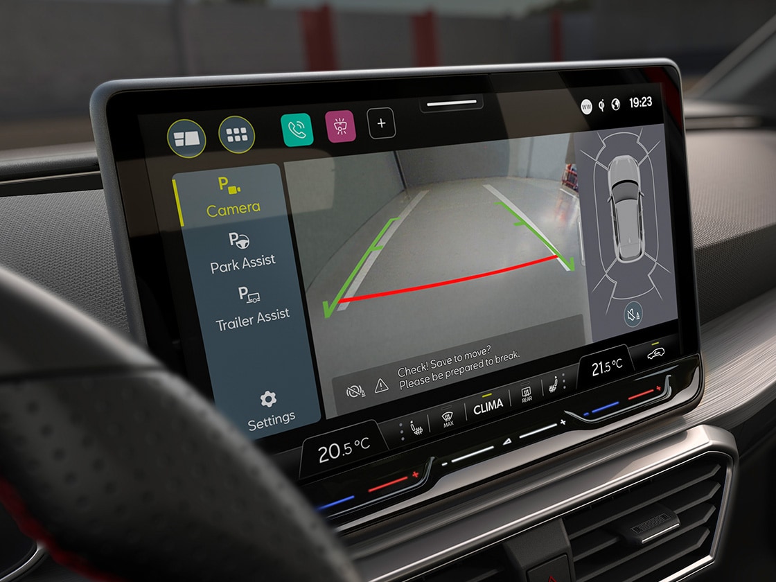 Vista interna della Seat Leon, dove si possono notare il touchscreen e il sistema di assistenza al parcheggio, per mostrare che il conducente può parcheggiare con facilità grazie a questa tecnologia.