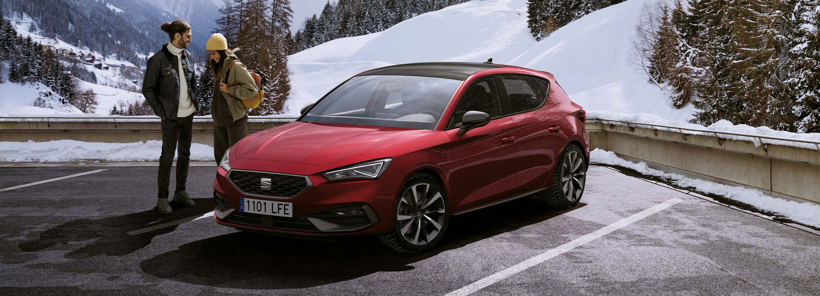 Due persone in piedi accanto a una SEAT Leon rossa in un ambiente innevato all’aperto, per dimostrare che è possibile usufruire di servizi di assistenza ovunque.