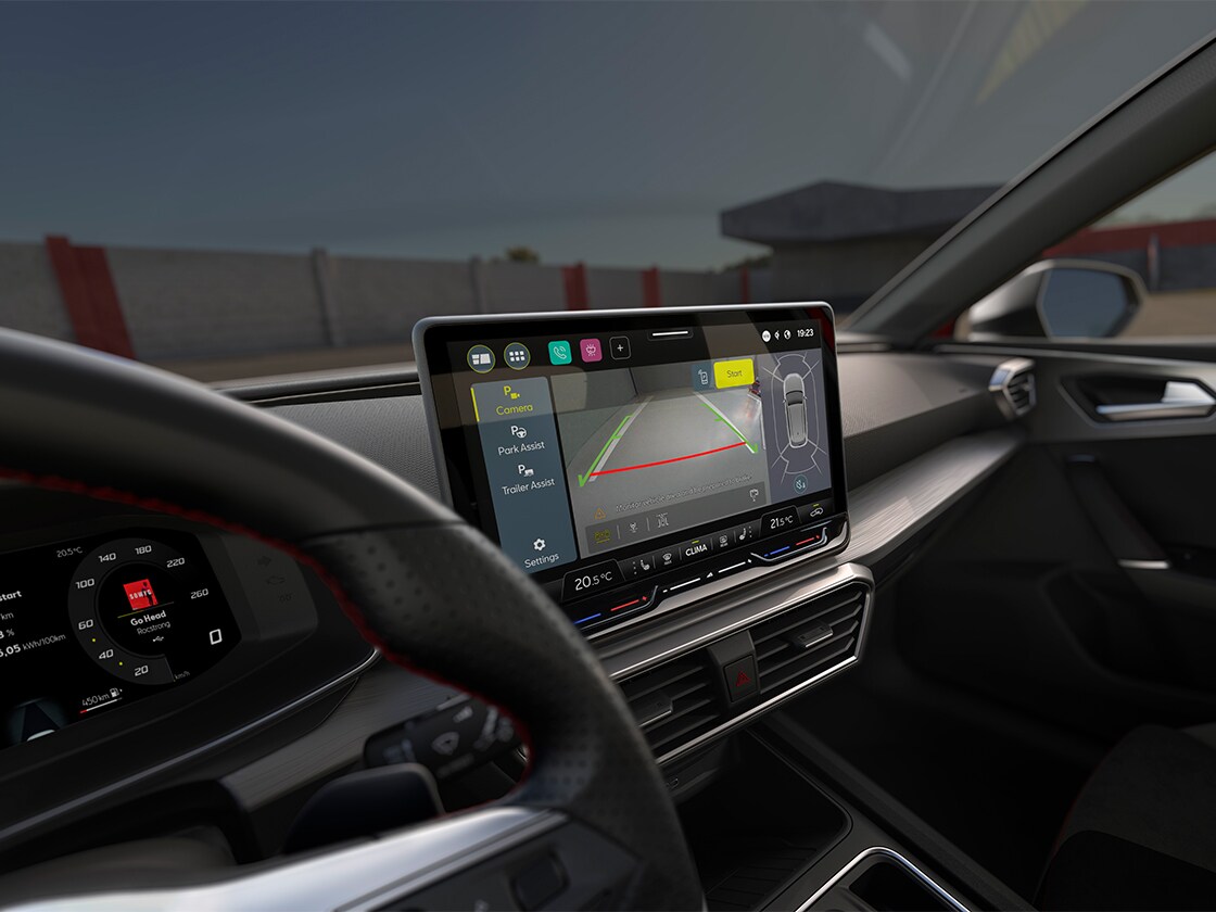 Vista degli interni di SEAT Leon Sportstourer con touchscreen e sistema di assistenza al parcheggio per parcheggiare agevolmente.