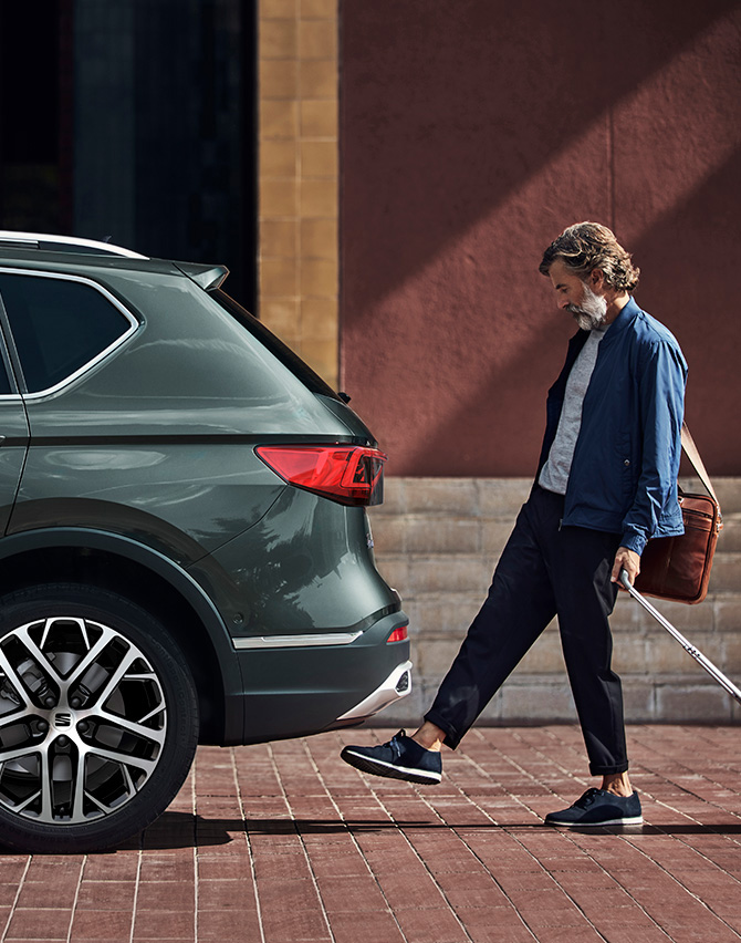 Man beside the new SEAT Tarraco XPERIENCE with alloy wheels