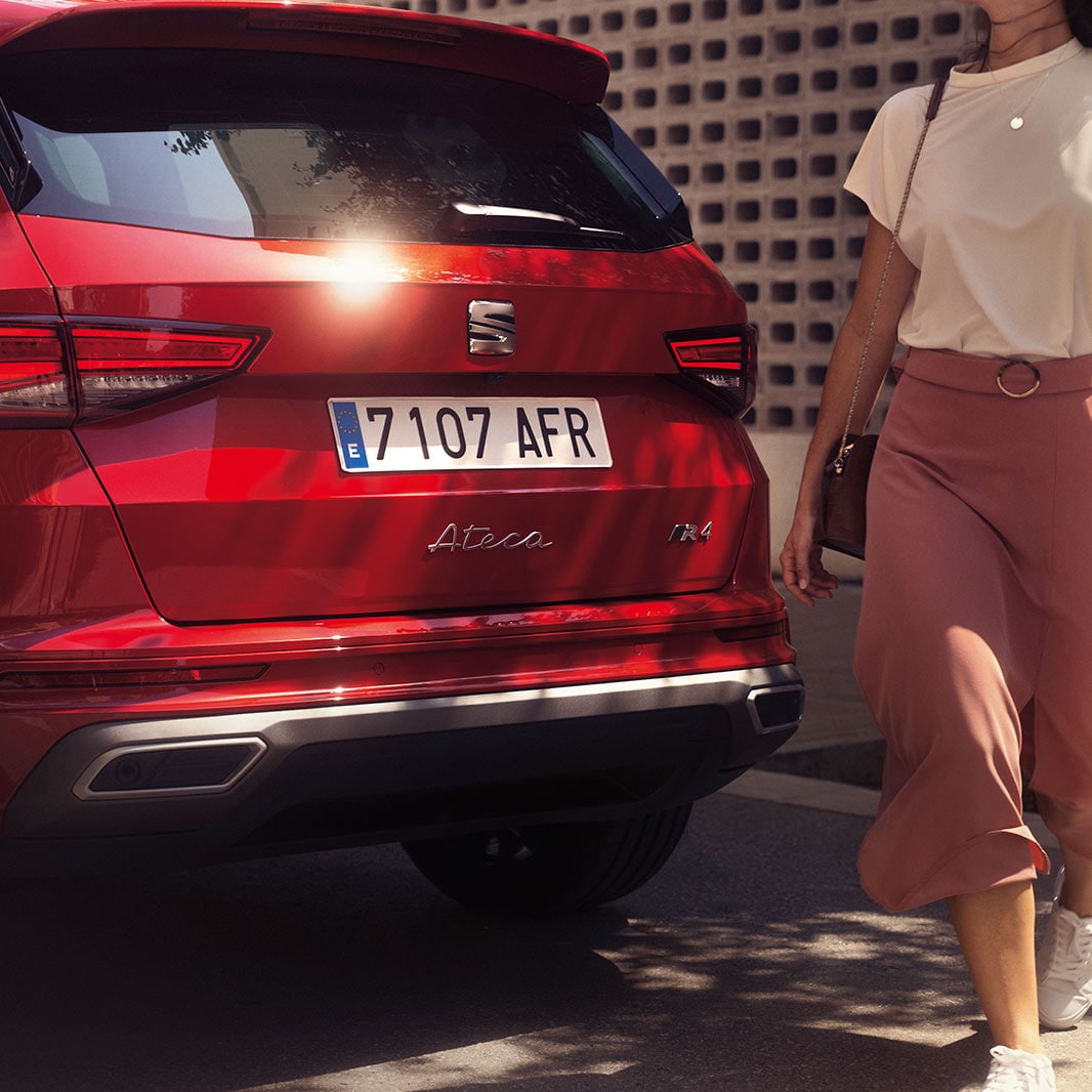 Due volumi SEAT Leon Silver in un parco di notte con, a lato, un uomo e una donna in piedi – Offerte sull’usato SEAT
