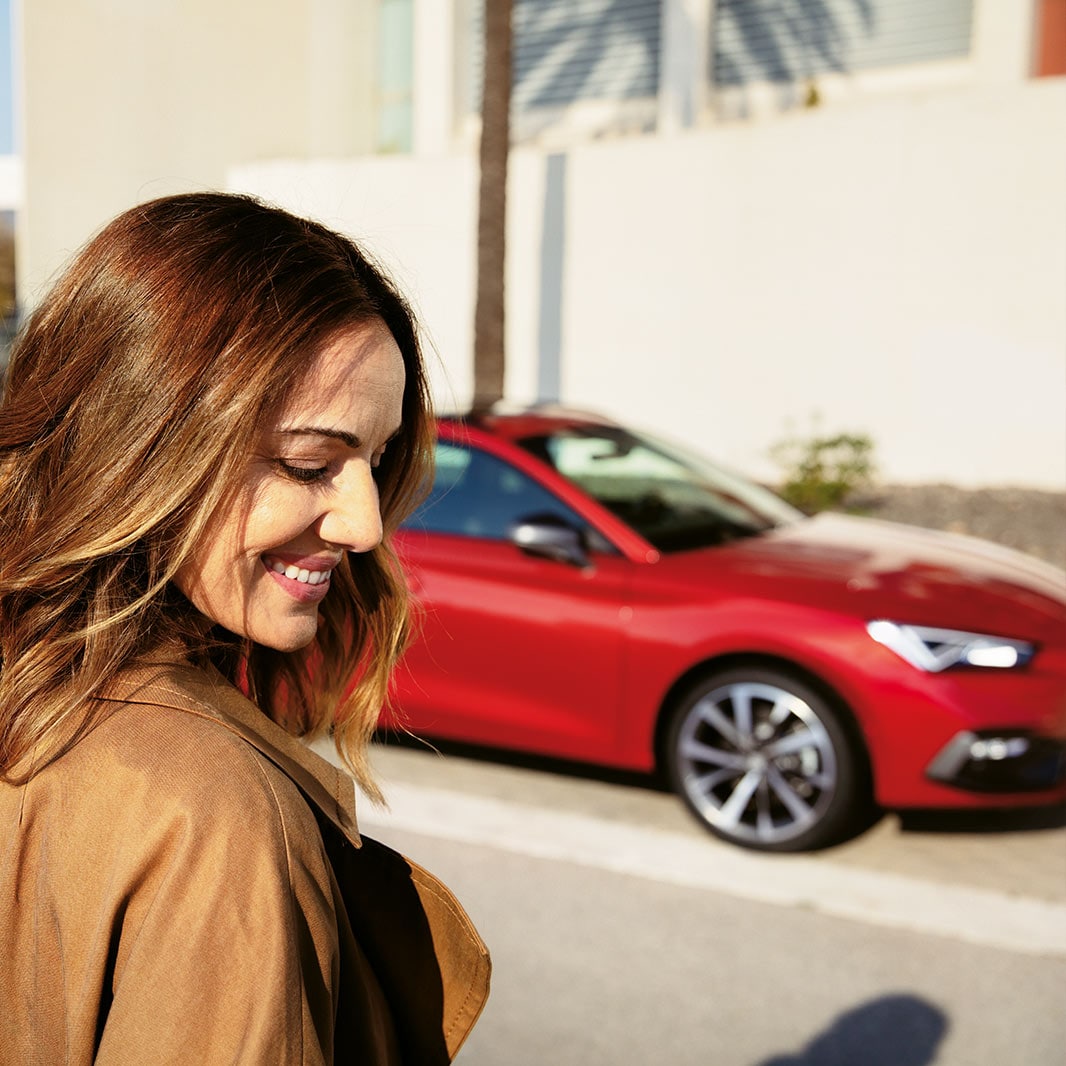 Immagine dell’abitacolo con un uomo al volante e una donna seduta sul sedile del passeggero con una mano dentro la borsa – Offerte vetture usate SEAT
