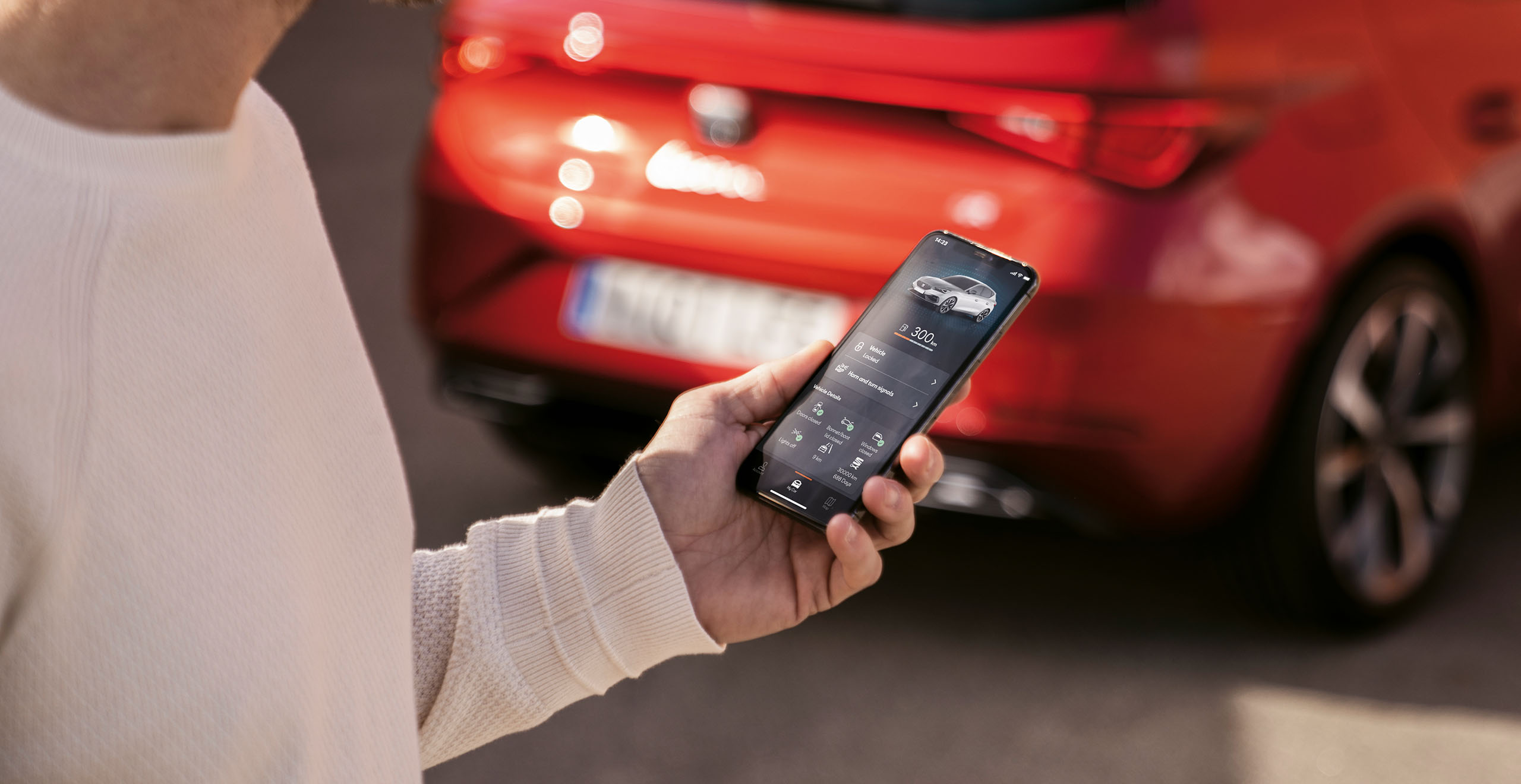 man-looking-at-seat- connect-on-phone-and-red-SEAT-Leon-5D-in-the-background