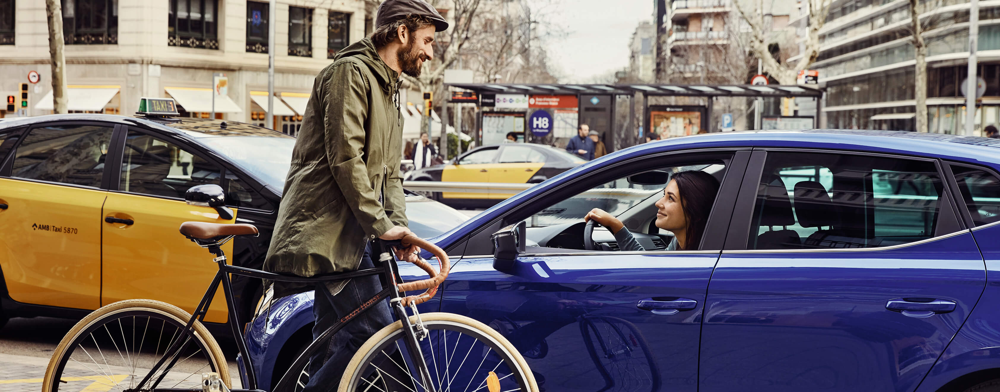 Servizi, assicurazione e manutenzione per vetture nuove SEAT – Uomo in bicicletta davanti a una vettura SEAT