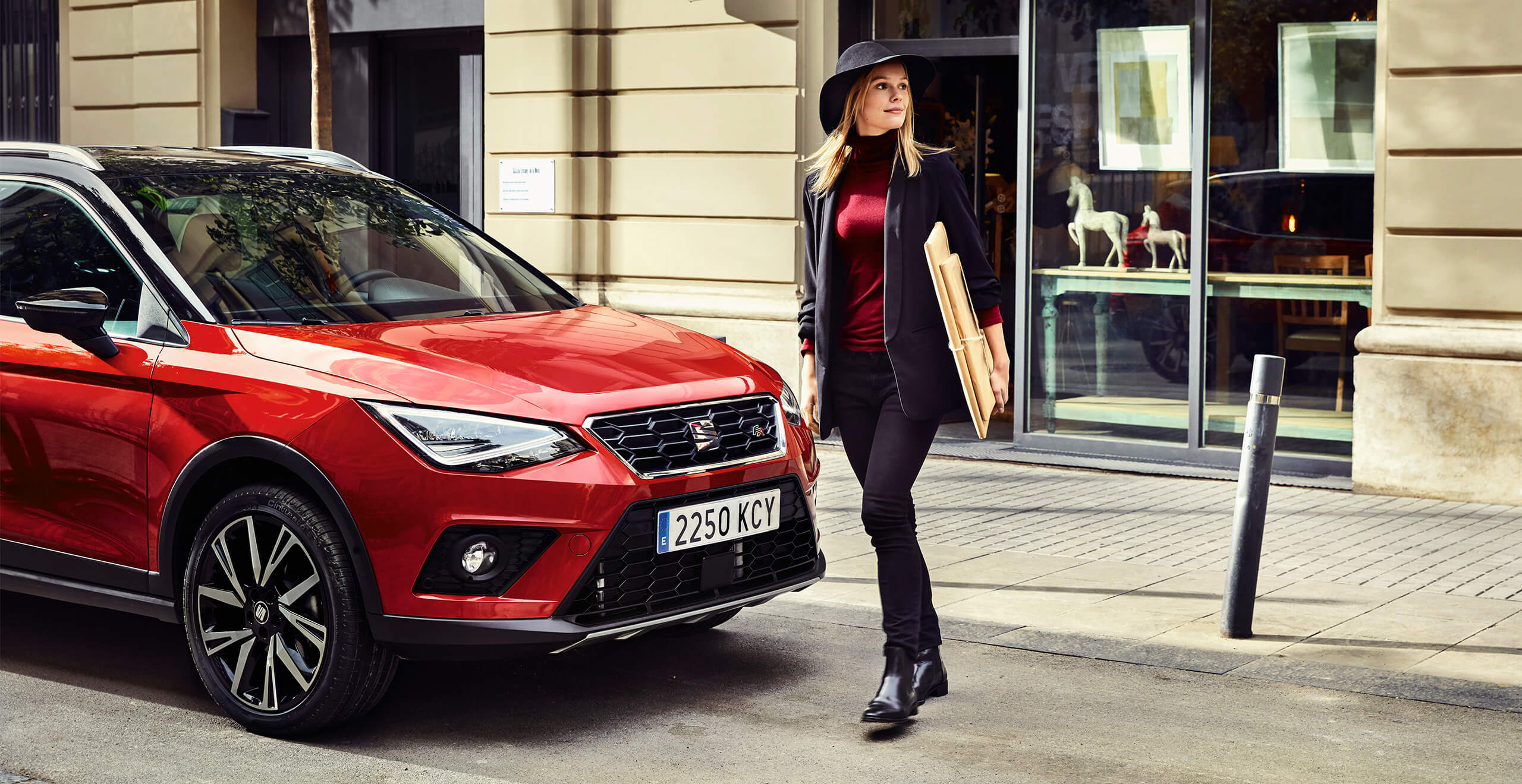 Servizi e manutenzione per vetture nuove SEAT – Donna cammina davanti a un SUV crossover SEAT Arona