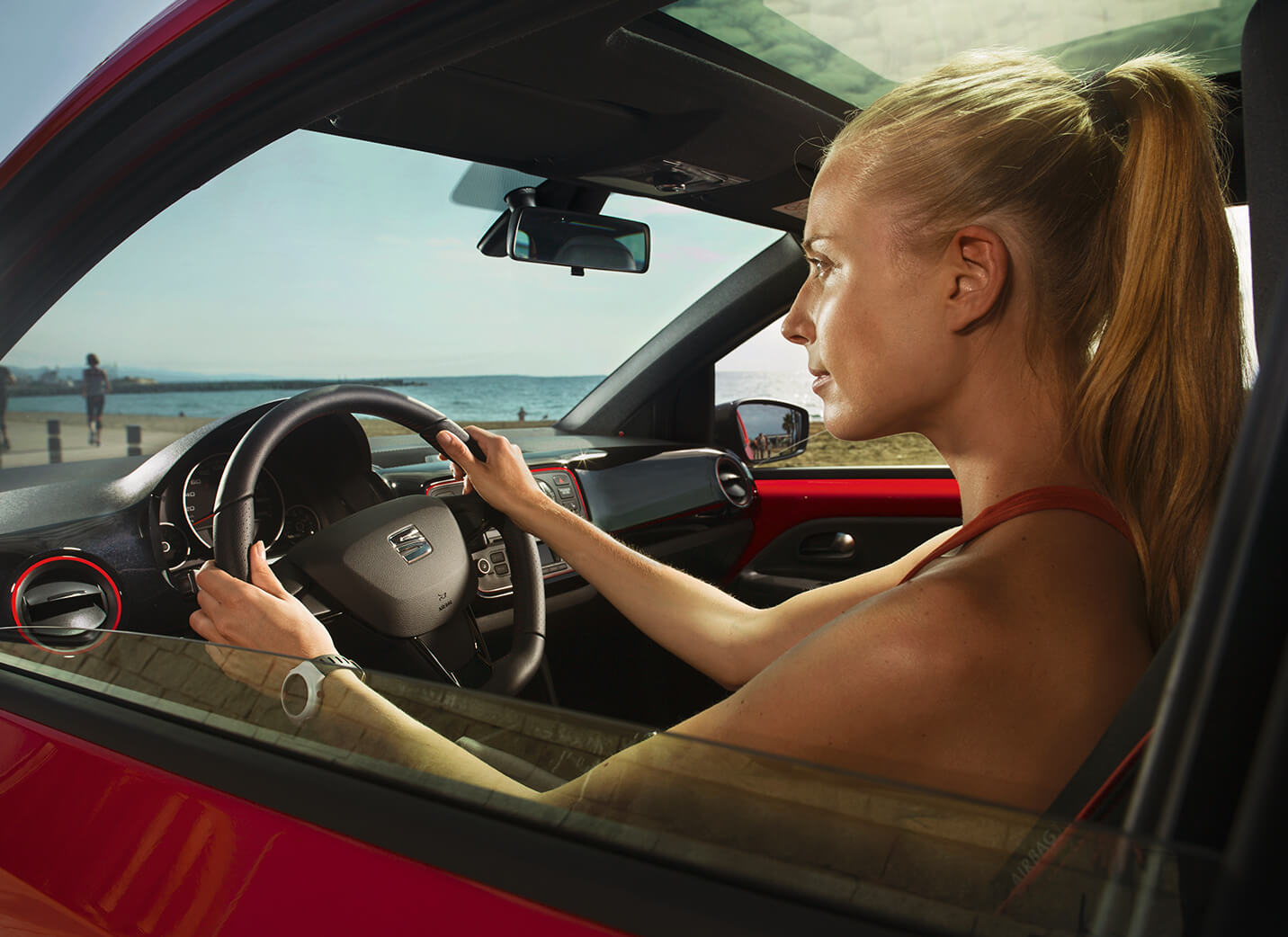 Servizi e manutenzione per vetture nuove SEAT – vista laterale di una donna alla guida di una nuova SEAT rossa
