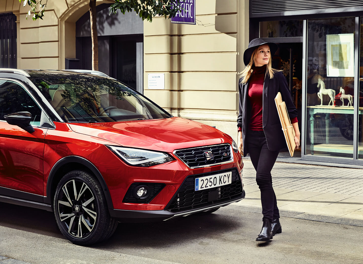 Servizi e manutenzione per vetture nuove SEAT – Donna cammina davanti a un SUV crossover SEAT Arona