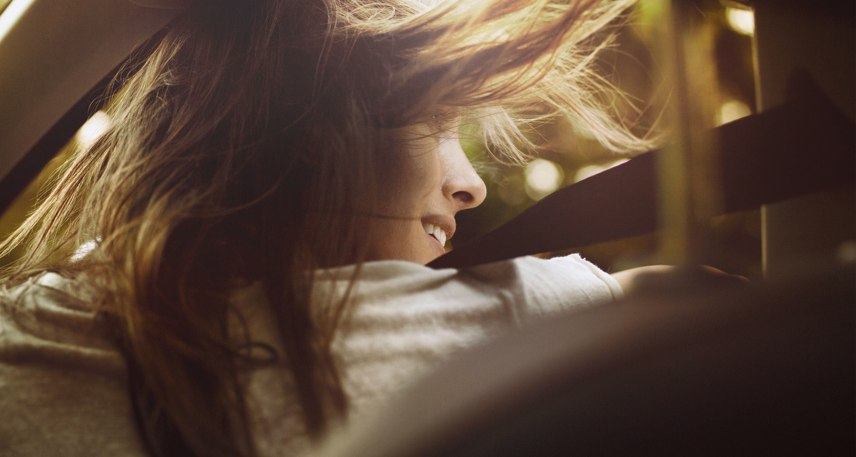 Servizi per vetture nuove SEAT – Immagine a distanza di una donna che esce da una vettura con i capelli al vento