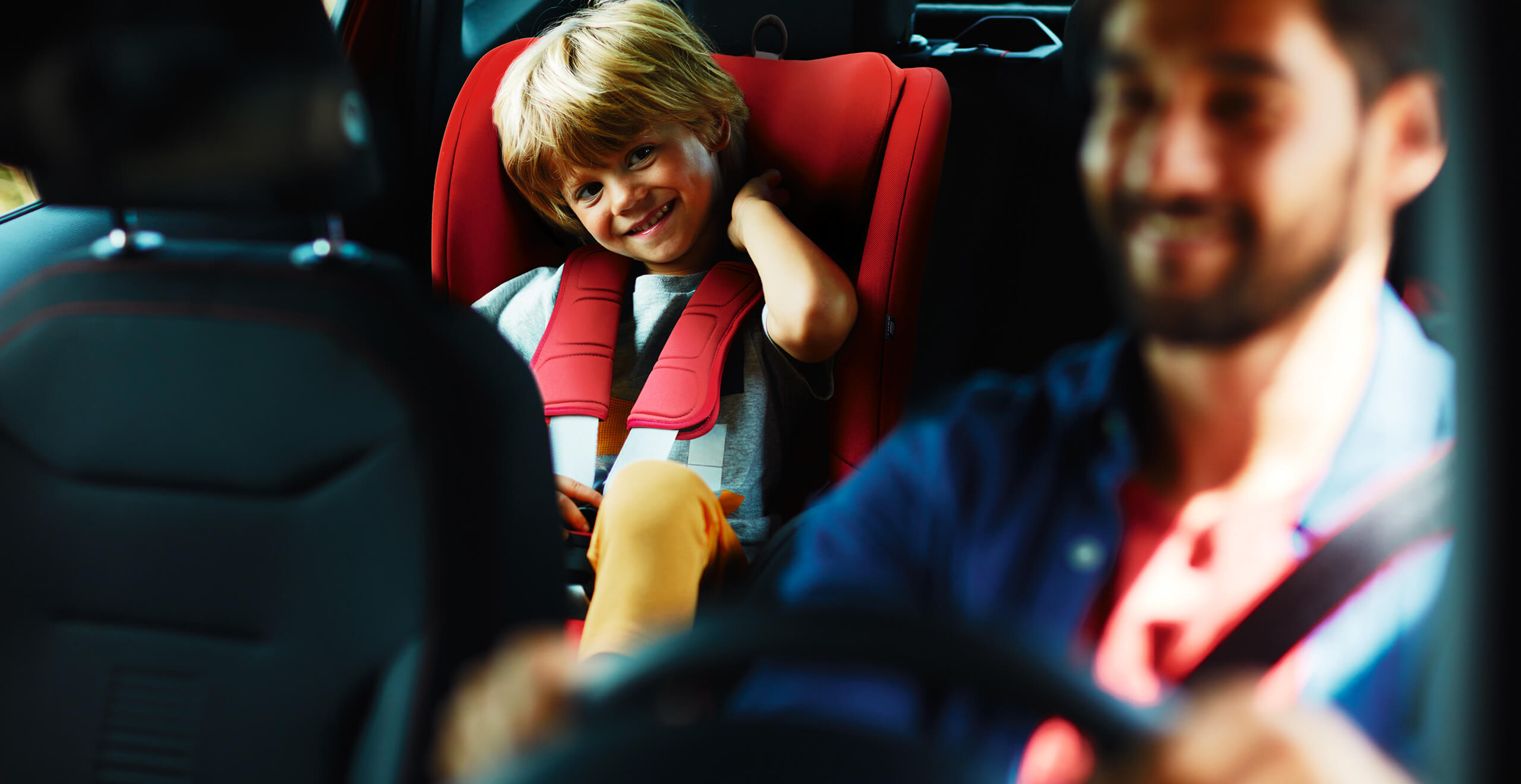 Manutenzione ed estensione di garanzia per vetture nuove SEAT – un bambino sul seggiolino con il padre alla guida, vista interna