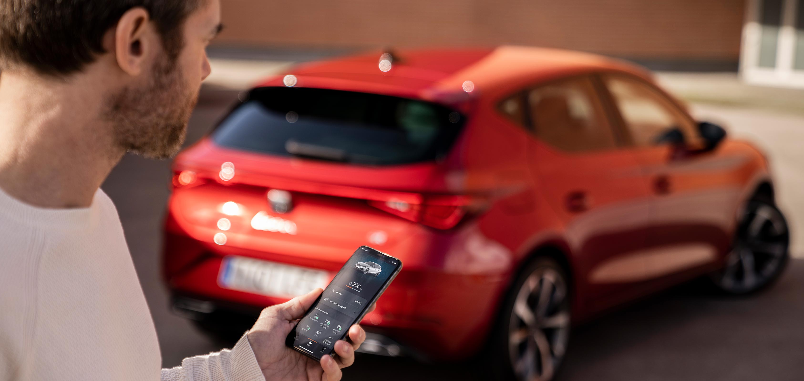 Uomo che controlla l’app My SEAT davanti alla vettura